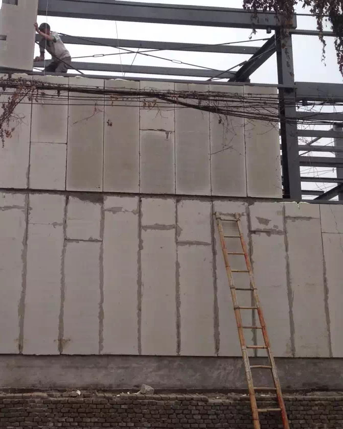 工作人員正在鋼結構上拼裝輕質隔墻板