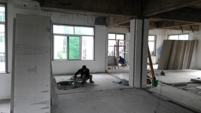 工人正在粉刷輕質(zhì)墻板，對輕質(zhì)墻板進行拼裝作業(yè)